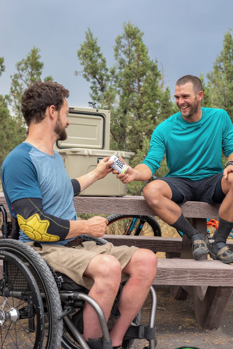 Camping cooler packed with ice, sealed food containers, and cold drinks
