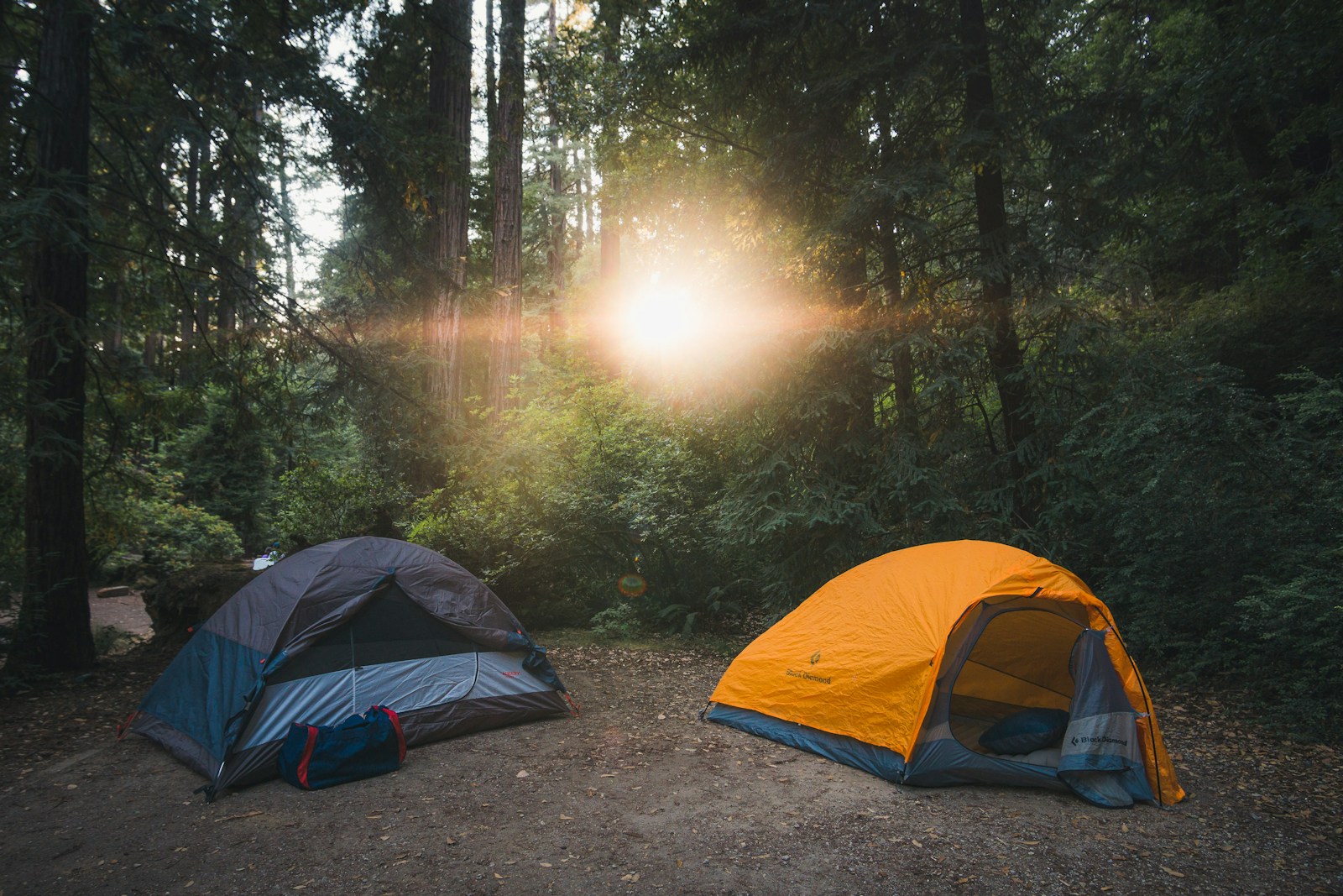 Tent, sleeping gear, camp kitchen supplies, and water organized before a camping trip