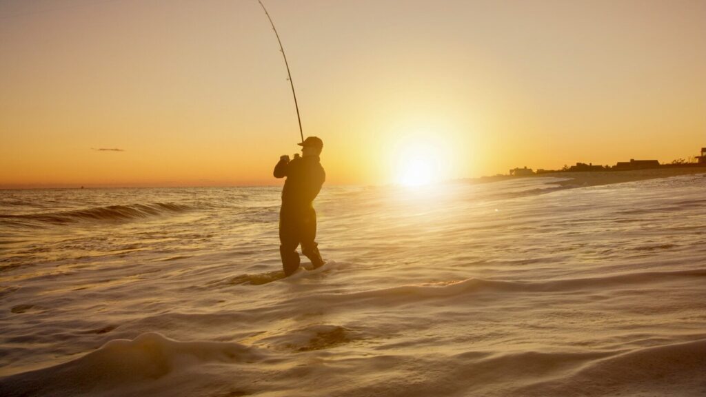 Angler checking calm lake conditions at dawn before deciding whether to fish