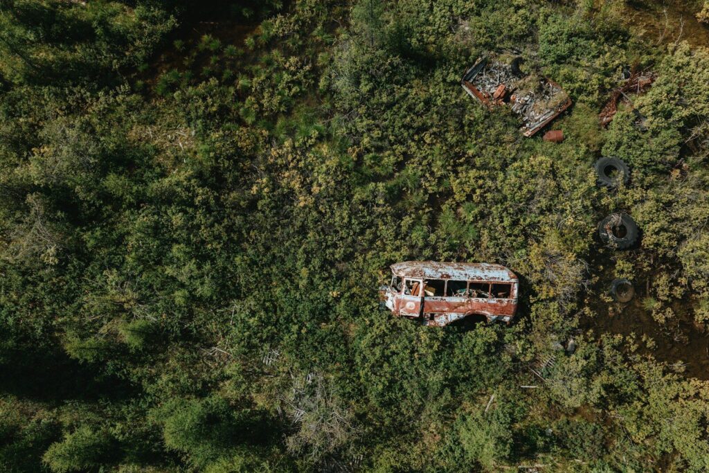 Hikers sharing a busy public-land trailhead with parked vehicles and open mountain terrain beyond
