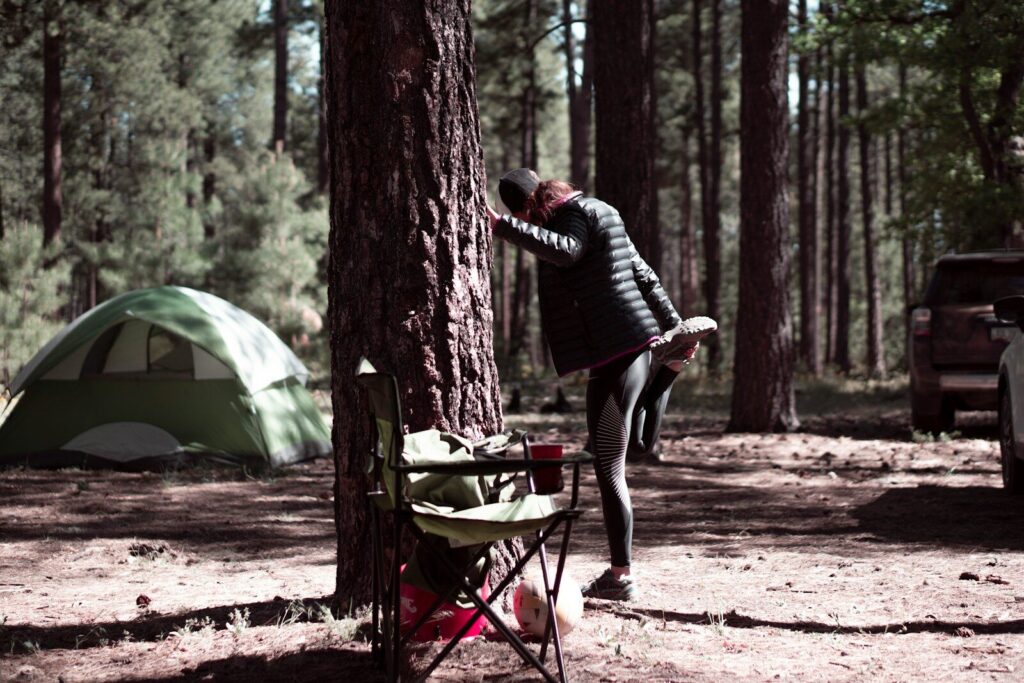 Camper carrying a small trowel and waste kit on a primitive campsite trail
