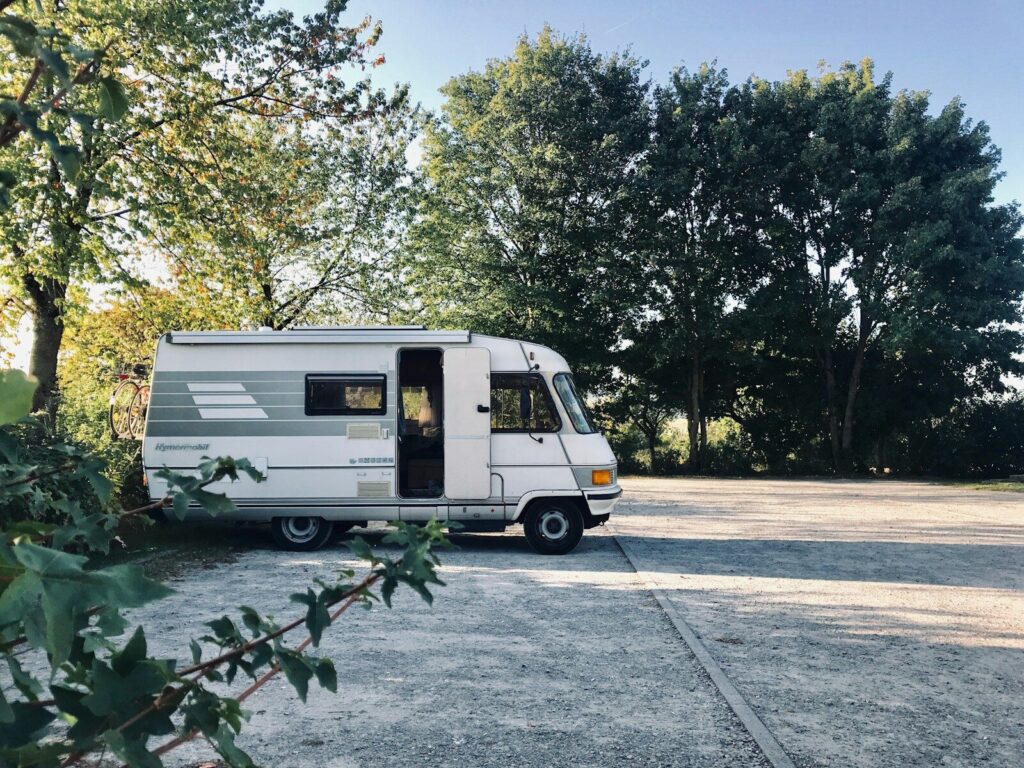 RV parked overnight in a well-lit retail parking lot while traveling